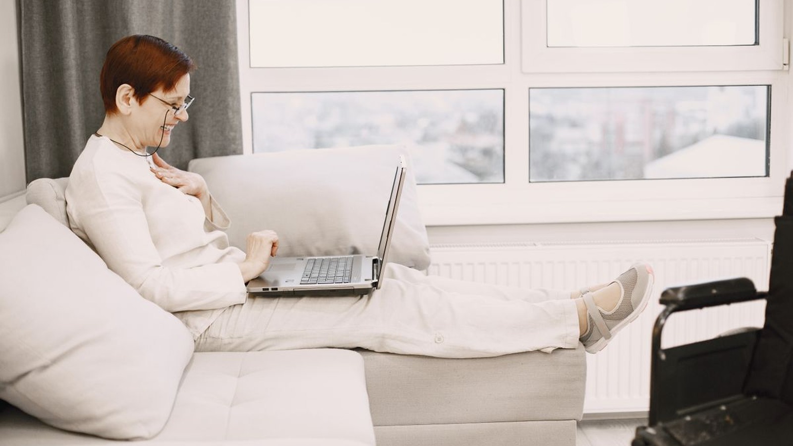 A senior woman on a video call from her couch at home, representing telehealth reaching people wherever they are