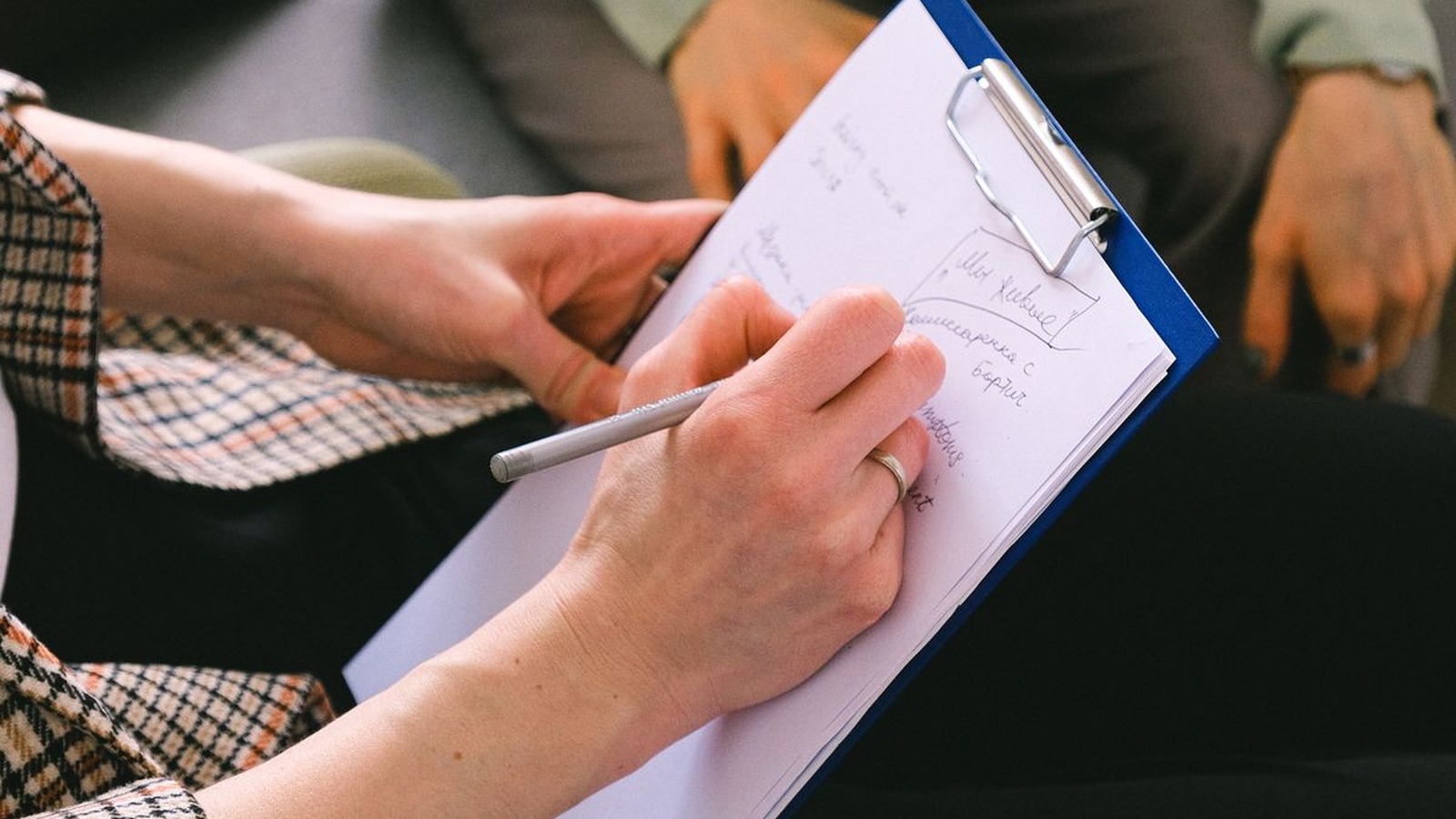 A clinician taking notes during a telehealth-style consultation, representing a Lumu Health session